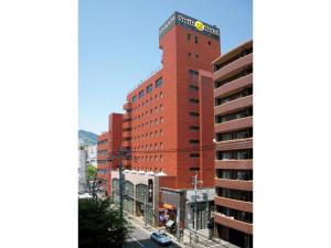 佐世保市にあるSmile Hotel Sasebo - Vacation STAY 92136vの上に看板がある高い赤い建物