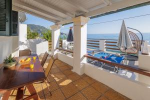 a balcony with a table and a view of the ocean at Josef and Marina House in Agios Gordios