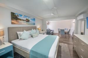 a bedroom with a large bed and a table at Blue Haven Holiday Apartments in Christ Church +28 photos