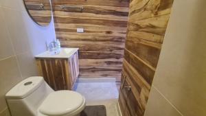 a bathroom with a toilet and a wooden wall at Casa Maya Mendihuaca in Playa Mendiguaca
