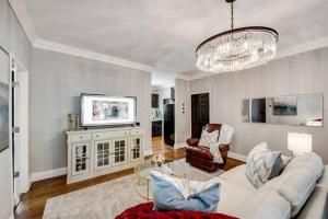 ein Wohnzimmer mit einem weißen Sofa und einem Kronleuchter in der Unterkunft Elegant Swiss Ave Condo Premier Dallas Location in Dallas