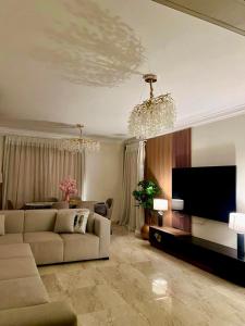 a living room with a couch and a flat screen tv at Elegant apartment in New cairo