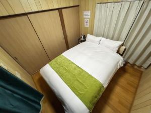 a small bedroom with a bed with a green blanket at Funabashi - House - Vacation STAY 19790 in Funabashi