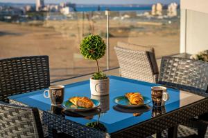 a table with two plates of croissants and two cups at Majestic Sunset Salt Lake Views 300m From Beach in Larnaka