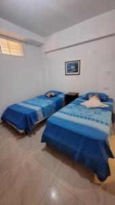 2 Betten in einem Zimmer mit blauer Bettwäsche in der Unterkunft Hermoso Apartamento vacacional in Porlamar