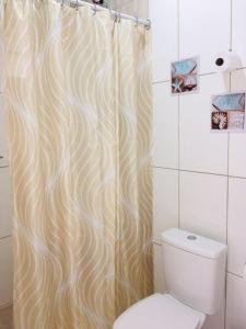 a bathroom with a shower curtain and a toilet at Mar Doce Lar Suítes Trindade in Trindade +36 photos