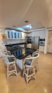 eine Küche mit einer schwarzen Theke und Stühlen in der Unterkunft Hermoso Apartamento vacacional in Porlamar