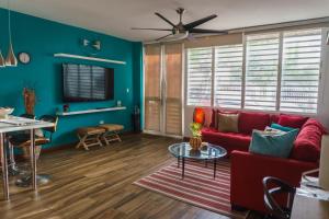a living room with blue walls and a red couch at CozyBeach large 1BdrApt 50 steps from Atlantic Ocean private street between Ocean Park & Isla Verde 5 mins from Airport in San Juan