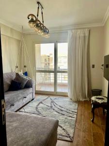 a living room with a couch and a large window at Elegant apartment in New cairo