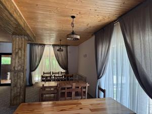 a dining room with a table and chairs and curtains at Vaya Retreat in Săsenii Vechi