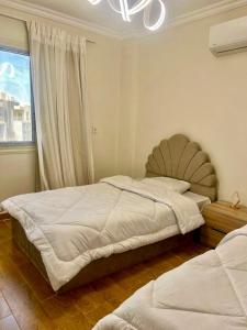a bedroom with two twin beds and a window at Elegant apartment in New cairo +40 photos