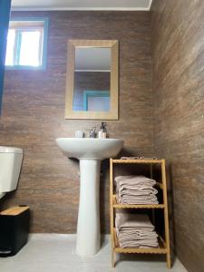 Un baño con lavabo, espejo y toallas. en Cielo Tiny House, en San Pedro de Atacama