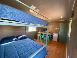 a bedroom with a bunk bed and a kitchen at Cielo Tiny House in San Pedro de Atacama