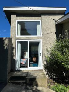 a white window in a house with at Cozy and quiet studio apartment with shared spa pool in Dunedin