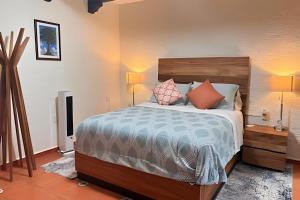 Un dormitorio con una cama grande con almohadas. en Diversión y bosque con amigos, en Villa Victoria