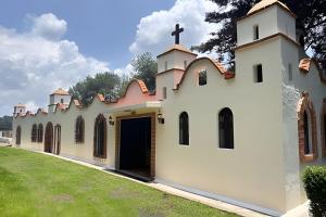 una iglesia con una cruz en el techo en Diversión y bosque con amigos, en Villa Victoria