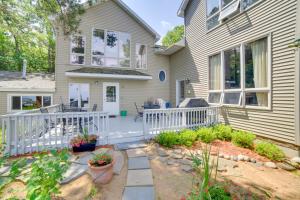 a house with a white fence and a patio at Private Beach! Year-Round Lake Superior Retreat in Marquette