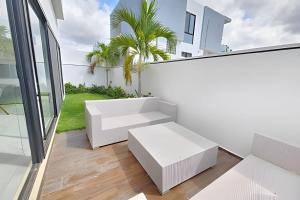 Una habitación con muebles blancos en un balcón. en Villa de Lujo Bahía de Banderas, en Cruz de Huanacaxtle