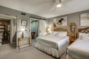 a bedroom with two beds and a bathroom at Steps to Shore Condo with Patio in West Palm Beach! in West Palm Beach