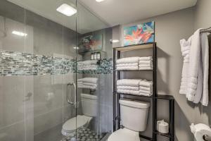 a bathroom with a shower and a toilet and towels at Steps to Shore Condo with Patio in West Palm Beach! in West Palm Beach +20 photos