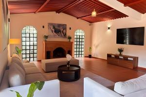 a living room with a fireplace and a tv at Refugio familiar en el bosque in Villa Victoria