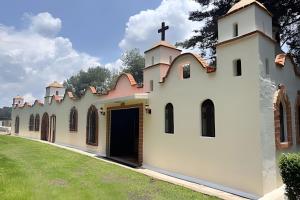 a church with a cross on the roof at Refugio familiar en el bosque in Villa Victoria