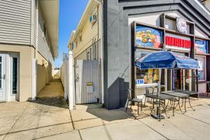 a table with a blue umbrella in front of a store at 1 Block to Beach Sea Isle City Retreat with Patio! in Sea Isle City