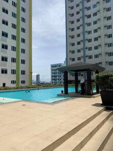 a man standing next to a pool in a building at Staycation in Quezon City in Manila +7 photos