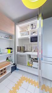 a kitchen with white shelves and a yellow ceiling at PARADISIAC LAGOON in Saint-François