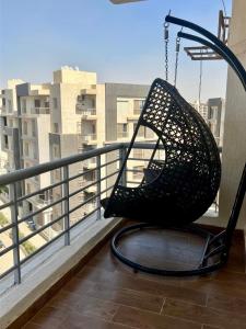 a swing on a balcony with a view of a city at Elegant apartment in New cairo