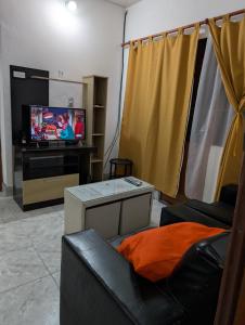 a living room with a couch and a tv at Casa equipada a 5 min del centro - Ideal para viajeros in Santiago del Estero