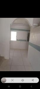 a white room with a window and a white tile floor at Villa in Berrechid