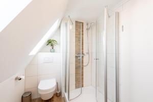 ザスバッハヴァルデンにあるSCHUSTERjunge Homes I Zentrale Ferienwohnung I neu & modern I 2 Zimmer bis 4 Personenのシャワーとトイレ付きのバスルーム +12枚の写真