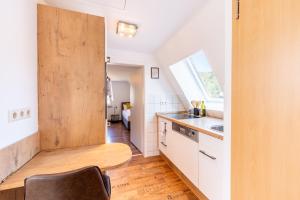 ザスバッハヴァルデンにあるSCHUSTERjunge Homes I Zentrale Ferienwohnung I neu & modern I 2 Zimmer bis 4 Personenの木製のドアとテーブル付きのキッチン