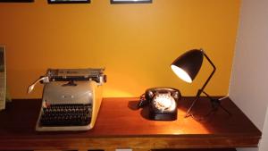a desk with a lamp and an old typewriter and a lamp at InspireBA - Terrace in Buenos Aires