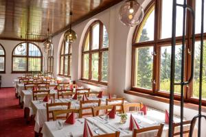 a row of tables in a room with windows at Hotel Tanečnica in Pustevny +62 photos