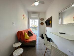 a small living room with a couch and chairs at Localização Perfeita na Mirim! 100m da Praia! in Samaritá