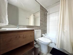 Un baño con inodoro, lavabo y ducha. en Parque Ohiggins I Movistar Arena, en Santiago