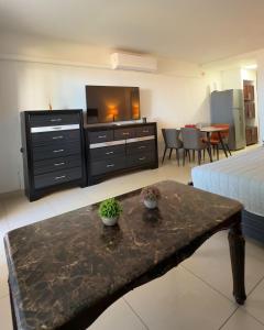 a room with a bed and a table with a tv at Maho Beach Beautiful Garden Studio in Maho Reef +15 photos