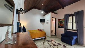 sala de estar con cama y silla azul en MAGNOLIAS, en Antigua Guatemala