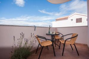 d'une terrasse avec des chaises et une table sur un balcon. dans l'établissement Apartments Beader, à Brodarica