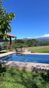 a swimming pool in a yard with a view of a field at Quinta La Lomita in Turrialba