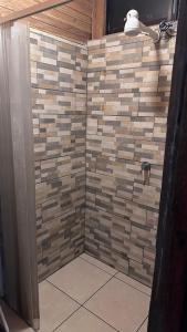 a shower with a tile wall in a bathroom at Quinta La Lomita in Turrialba +25 photos