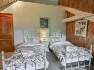 two white beds in a bedroom with a wooden wall at Les Roches de Roquecor in Roquecor +44 photos