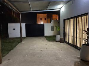 サン・ペドロにあるCiudad Abierta San Pedro Bs Asのフェンスと植物のある空のガレージ