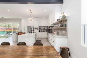 une cuisine avec des armoires blanches et une table en bois dans l'établissement Modern Dreamland in Old Town, à Scottsdale 35 autres photos