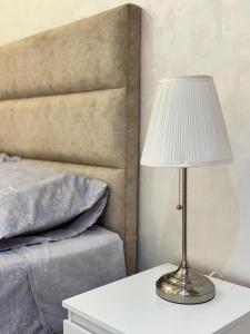 a lamp sitting on a table next to a bed at Appartement élégant au cœur de Ain Hayani in Tangier +24 photos