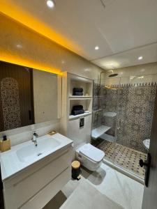 a bathroom with a sink and a shower and a toilet at Appartement élégant au cœur de Ain Hayani in Tangier