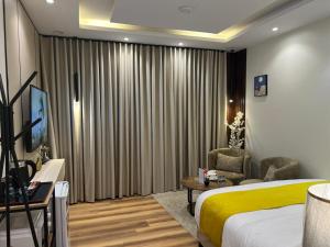 a hotel room with a bed and a chair at Hala 9B استوديو فندقي فاخر في قلب الملقا in Quai