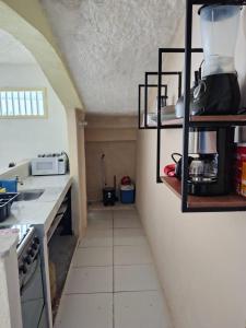 a kitchen with a counter and shelves in a room at ossos beach in Búzios +7 photos